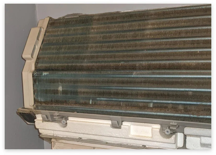 Dirty mini split air conditioner coil before cleaning, showing dust and debris buildup