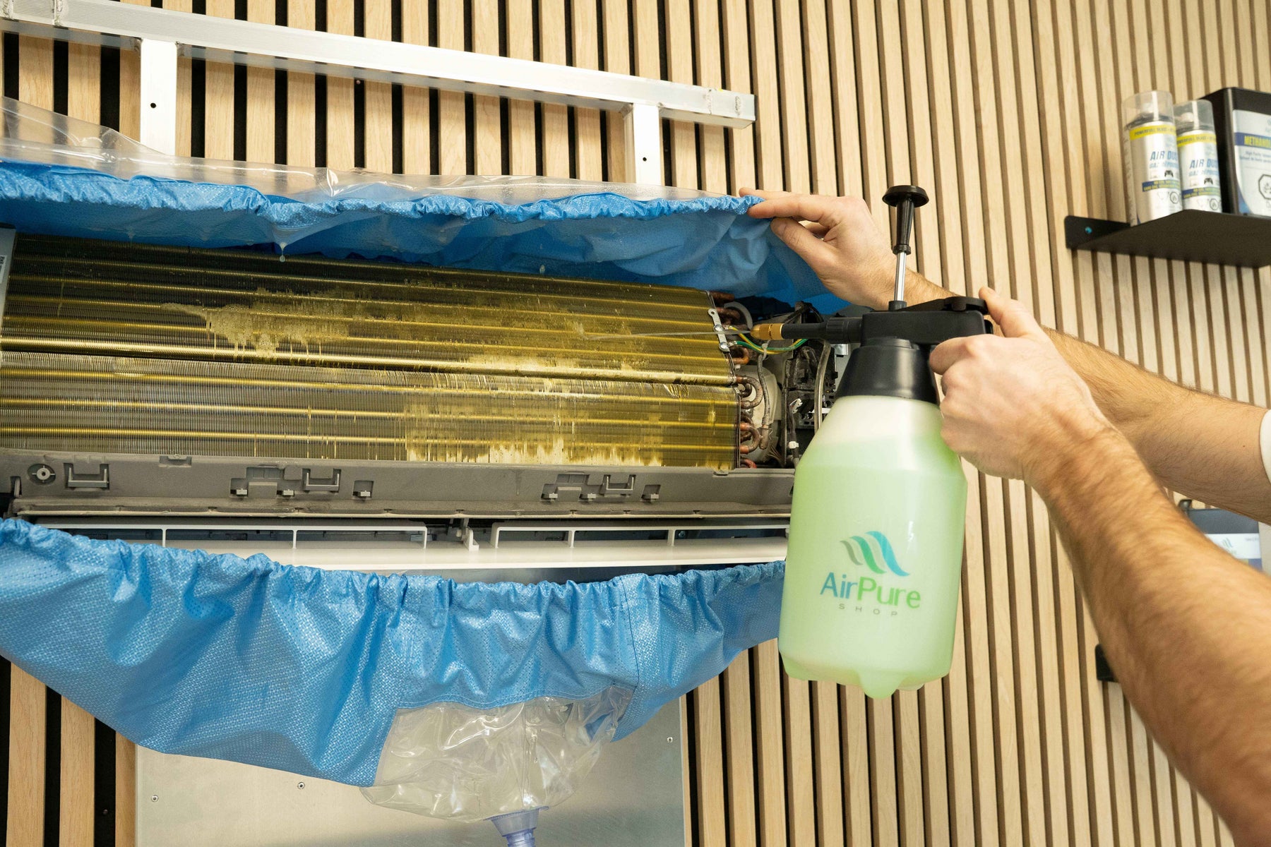 HVAC technician deep cleaning a mini split indoor unit evaporator coil with foaming coil cleaner